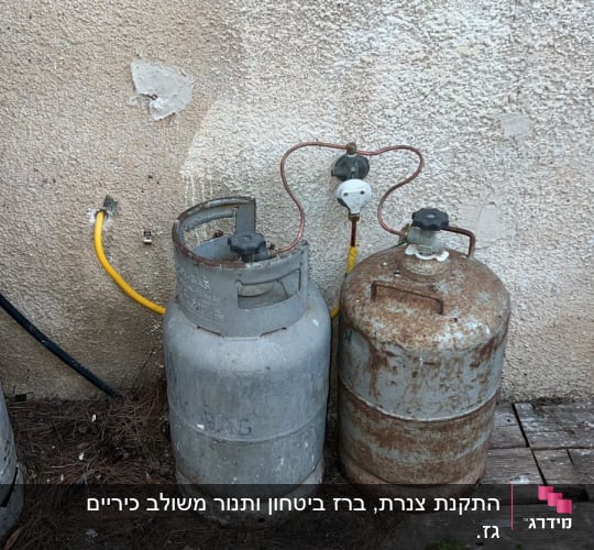 שני בלוני גז עם צינורות וכלי עבודה על הרצפה